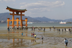Visitors approach the torii at low tide...